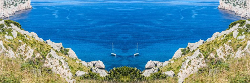 Panorama, secluded cove in picturesque Seascape with 2 sailboats on the island of Mallorca, Spain.