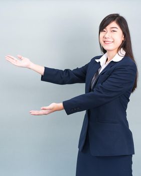 Asian woman in suit open hand palm gestures with empty space isolated on gray background