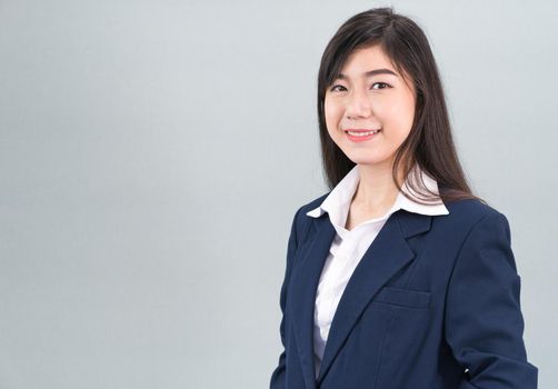 Portrait of asian business woman standing isolated on gray background