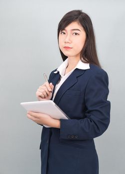 Woman in suit using computer digital tablet isolate on gray background