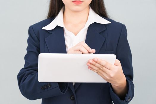 Woman in suit using computer digital tablet isolate on gray background