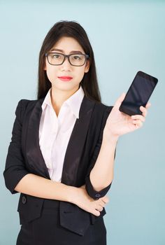 Young women in suit holding her smartphone standing against blue background