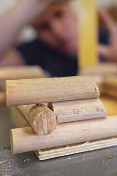 A male carpenter works with a tree in a carpentry shop. Making a mock-up of a log house