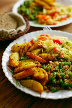 Food on a plate. Delicious and delicious homemade lunch: fried potatoes, string beans and a portion of salad. Top view.