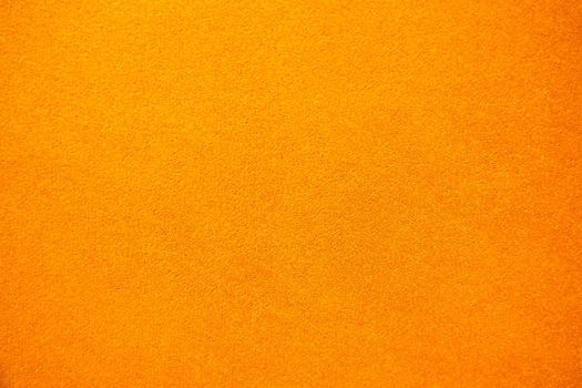 Bright solid color background. Empty orange surface with fine texture. Preparation for designer or layout.