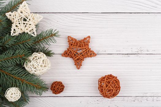 Top view of white rustic style wooden table decorated with white and brown rattan balls and stars. The concept of New Year and Christmas time