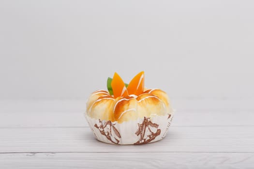 Selective focus, close up of cupcake with fruit pieces on white wooden rustic style table with space for text. High quality photo