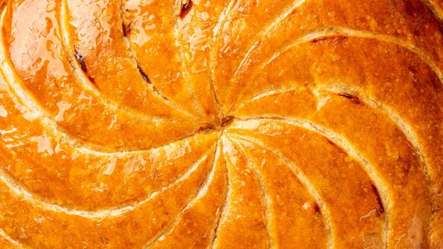 Detail shot of Epiphany cake or galette des rois in French shows the shiny texture of the puff pastry