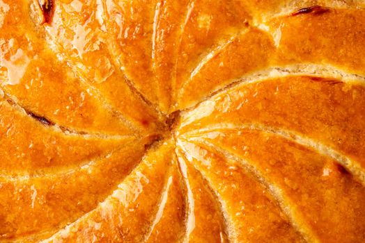 Detail shot of Epiphany cake or galette des rois in French shows the shiny texture of the puff pastry