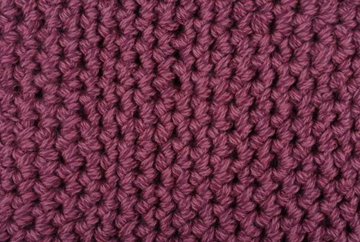 Purple knitted texture close up. Concept of cold weather and winter season