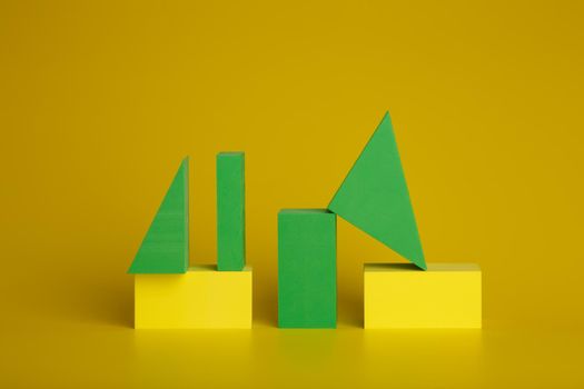 Abstract duotone background with green and yellow geometric figures, triangles and rectangulars on yellow background. High quality photo