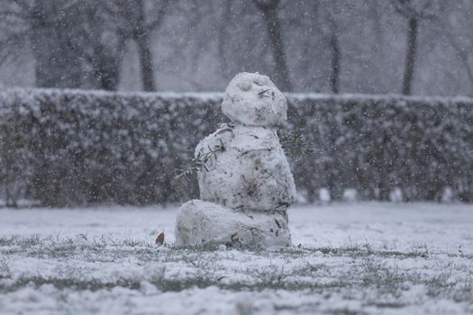 Madrid, Spain - January 07, 2021: Snowmen made by some kids, in the Buen Retiro park in Madrid, in the middle of a snowy day, due to a wave of polar cold.