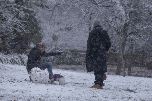 Madrid, Spain - January 07, 2021: People enjoying a walk through the Buen Retiro park in Madrid, in the middle of a snowy day, due to a wave of polar cold.