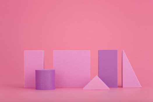 Abstract geometric composition with pink and purple geometrical figures on bright pink background with copy space. High quality photo