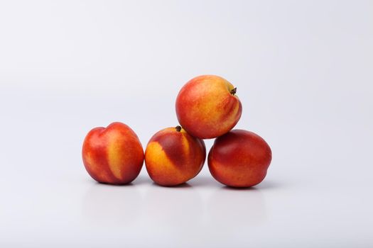 Bunch of fresh beautiful and glossy nectarines on white background with space for text
