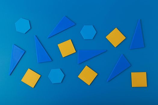 Abstract futuristic background with blue triangles, hexagons and orange squares on blue background