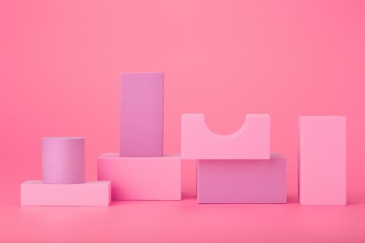Abstract still life with pink and purple geometric figures, cylinder, rectangular and others against light pink background