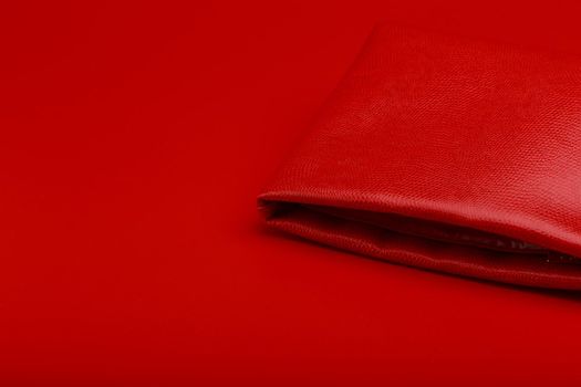 Red bag on red background with space for text. Concept of fashion or consumerism.