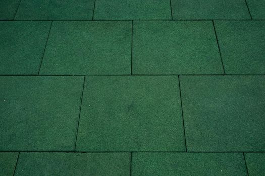 Green floor covering in the form of squares. Shot from above.