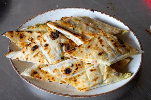 Beautifully grilled pieces of pita bread lie on a plate