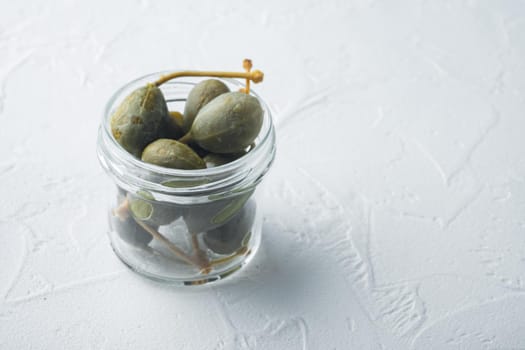 Organic pickled, canned capers, on white background with copy space for text