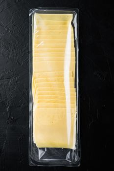 Slices of american cheese plastic pack, on black background
