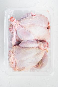 Plastic container with raw chicken set, on white background, top view