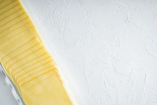 Slices of yellow cheese, sealed pack, on white background with copy space for text