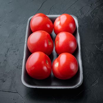 Fresh red organic tomatoes, on black background