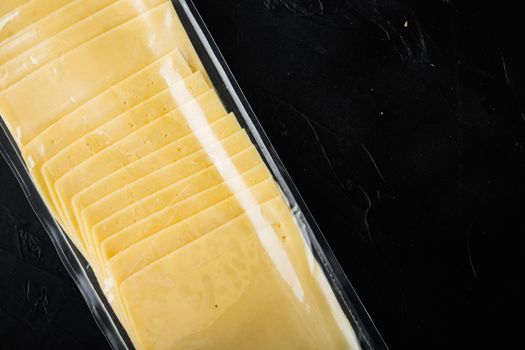Cheddar cheese in vacuum pack, on black background with copy space for text