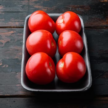 Red tomatoes, on dark wooden background