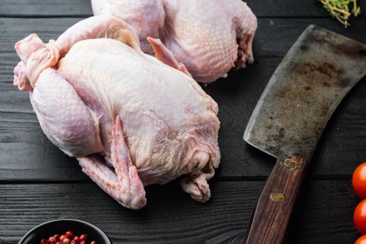 Raw coquelet chickens meat with herbs spices, on black wooden background
