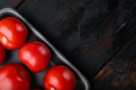 Red ripe tomatoes, on dark wooden background with copy space for text
