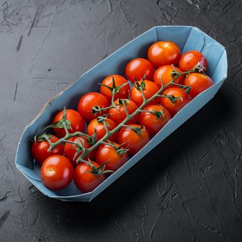 Red ripe cherry tomatoes, on black background