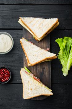 Homemade turkey club sandwich, on black wooden table, top view