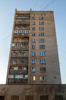 typical mid-russian silicate brick high rise condominium residential building, upward view on blue sky background