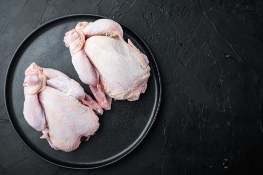 Organic whole fresh poussins, on black background, top view with copy space for text