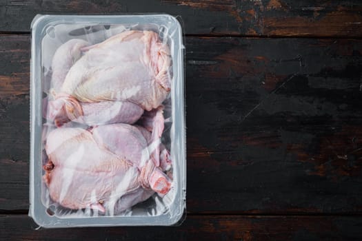 Raw chicken set in plastic vacuum tray, on old wooden table, top view with copy space for text