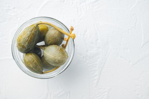 Organic pickled, canned capers, on white background, top view with copy space for text