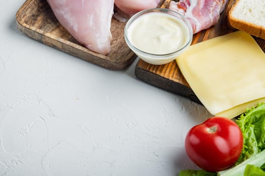 Ingredients for sandwich, bacon, cheese, tomato, chicken meat, lettuce, sauce, on white background with copy space for text