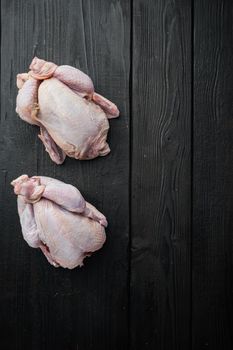 Organic whole fresh poussins, on black wooden table, top view with copy space for text