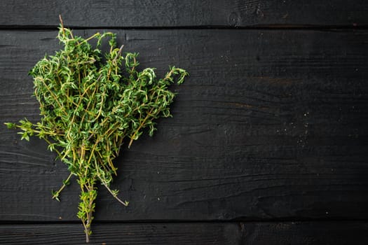 Thyme green fresh bunch, on black wooden background, top view with copy space for text