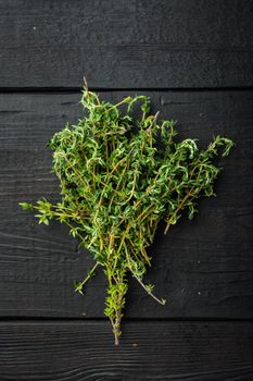 Thyme green fresh bunch, on black wooden background, top view