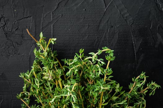 Thyme green fresh bunch, on black background, top view with copy space for text