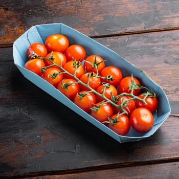 Red small cherry tomatoes, on dark wooden background