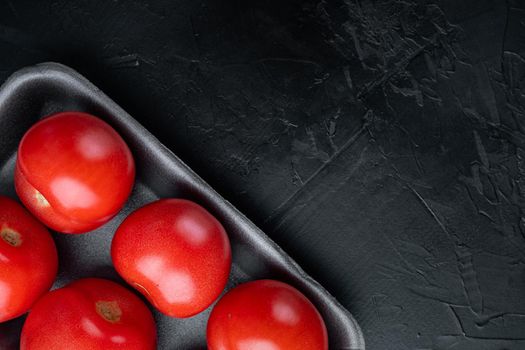 Red ripe tomatoes, on black background with copy space for text