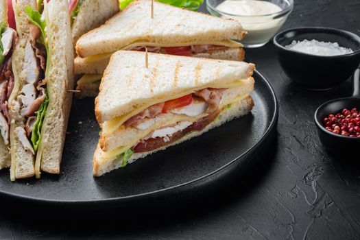 Homemade turkey club sandwich, on black background