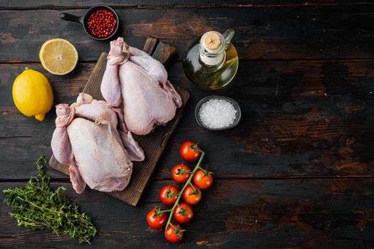 Fresh raw whole chicken carcass with ingredients, on old wooden table, top view with copy space for text