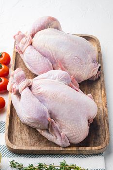 Raw organic uncooked whole chicken meat with herbs and ingredients, on white background