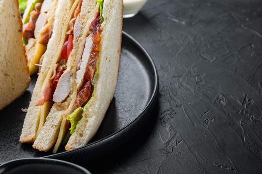 Club sandwich panini with ham, fresh tomato, cheese, on black background with copy space for text